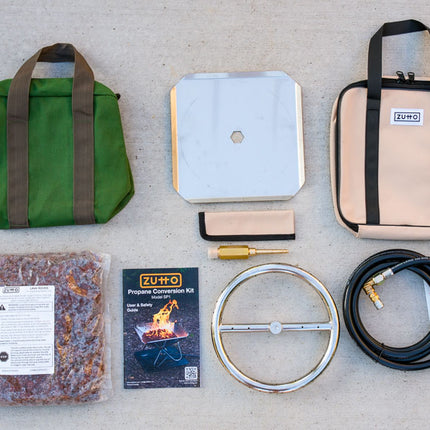 Overhead view of the complete Zutto SP1 smokeless propane gas adapter kit showing burner, tray, air mixer, regulator hose, lava rocks, canvas bags, protector sleeve, and user manual
